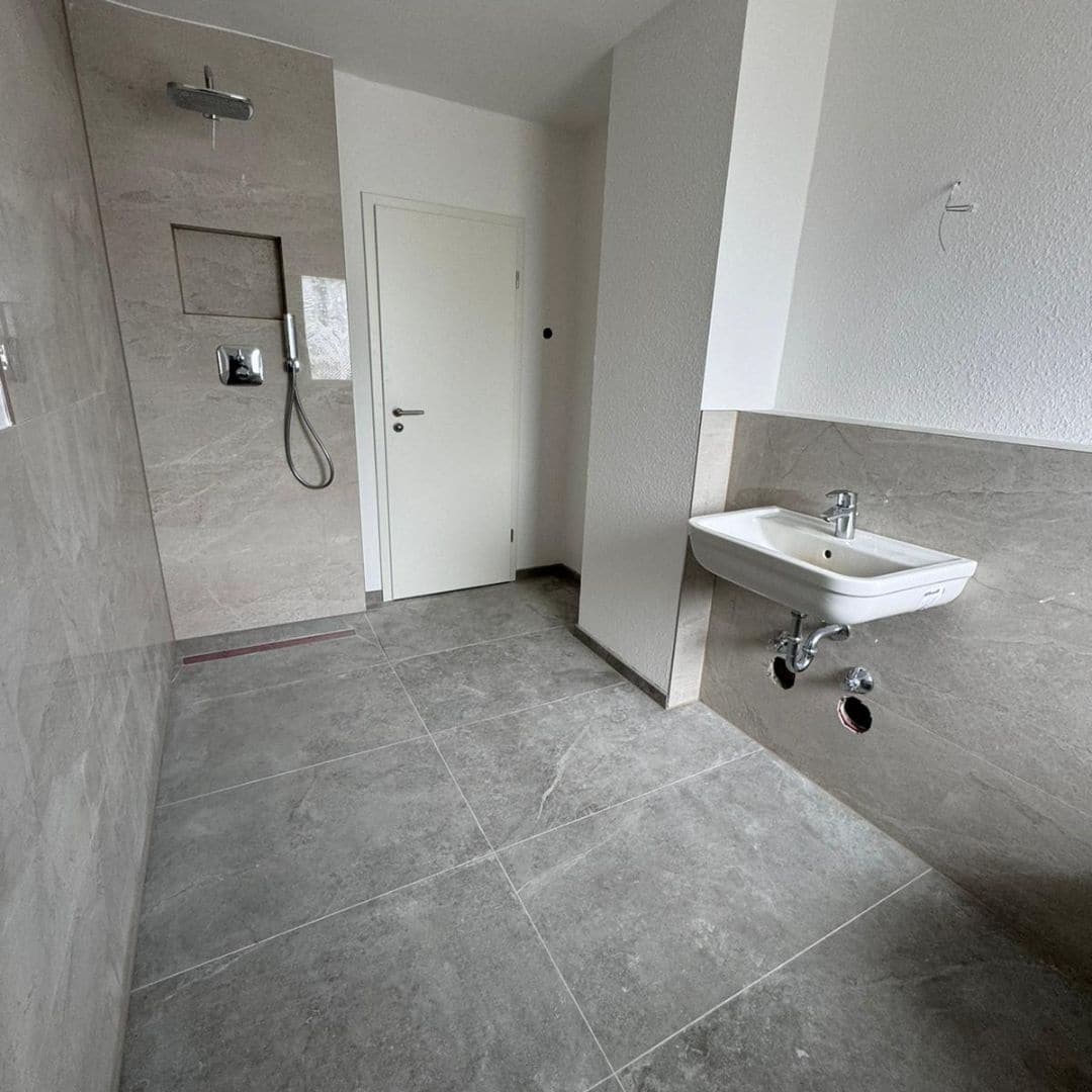 Referenzen, Erfahrungen, Schulterblick Gebrüder Queitsch GmbH Moers und in der Nähe - Badezimmer in Entstehung große Fliesen grau
